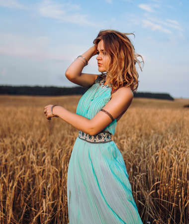 Beautiful Young Woman Dancing In The Field at sunsetの写真素材