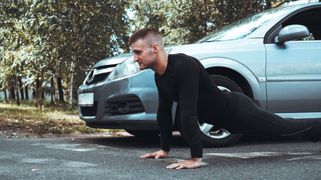 Handsome man near the car. The athlete wrung out next to the machine. Car VS man