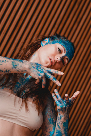 Portrait of beautiful woman with blue sparkles on her face. The concept of freaks and aliens. People...