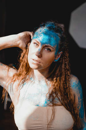 Portrait of beautiful woman with blue sparkles on her face. The concept of freaks and aliens. People are different from others. Individualityの写真素材