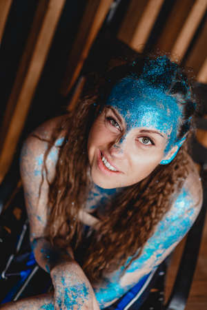 Portrait of beautiful woman with blue sparkles on her face. The concept of freaks and aliens. People are different from others. Individualityの写真素材