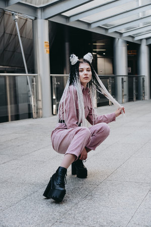 Young woman with futuristic looks. Girl with black and white dreadlocks or pigtails. Against the...
