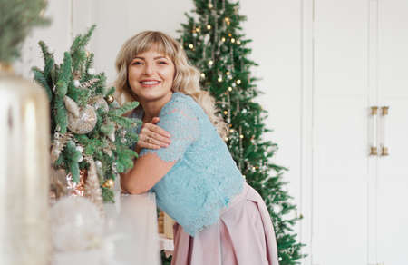 Charming Girl with Beautiful Make-up on Face in gold and white interior. Christmas Holidays, Merry Celebration with the Familyの写真素材