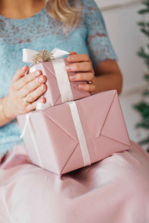 Hands holding gift present. Closeup of Female hands giving the gift in the New Year interiorの写真素材