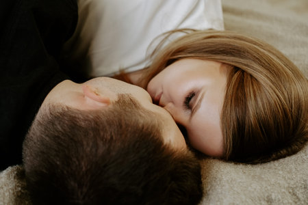 Close-up portrait of a young couple in bed at home - top view