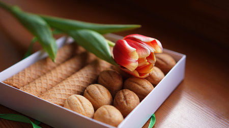 Shortbread cookies and tulips. Gift to the woman. Russian Sweets - oreshki cookies and tubesの写真素材