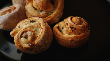 Chicken rolls from puff pastry on a black plate