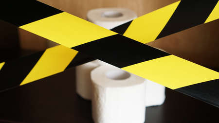 Stop panic - coronavirus. Rolls of Toilet paper behind the yellow tapeの写真素材
