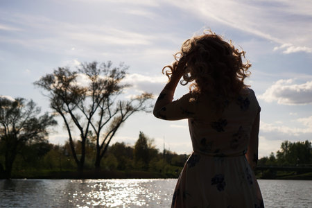 Portrait of woman in profile resting on the nature near the river. Sunny simmer day