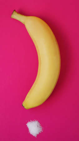 Banana and sugar on a pink background. Diet and healthy eating concept.の写真素材