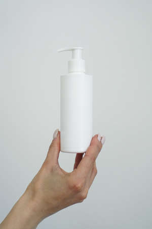 Hand hold blank white tube mock up isolated. Empty cream bottle mockup template holding in hands. Tube design presentation. Skin care mockupの写真素材