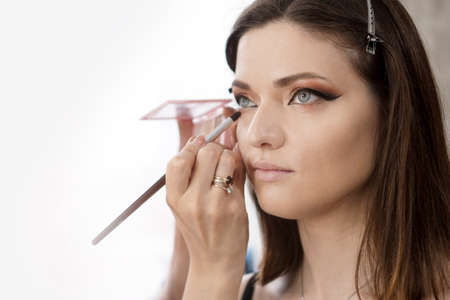 Young, beautiful girl put on make-up in a beauty salonの写真素材