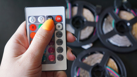 Remote control for change colors in hand on blurred background with led light