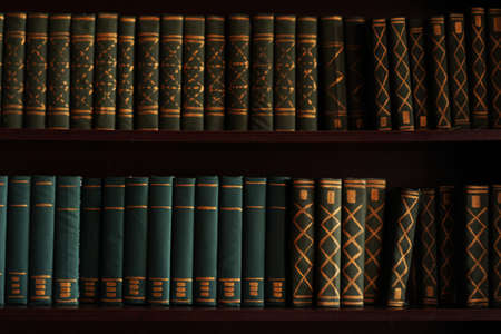 Old books on an archival shelf of library of storehouse. Two rows of booksの写真素材