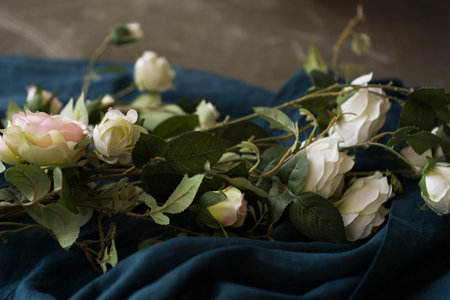 White flowers on the blue fabric background. Copy space.