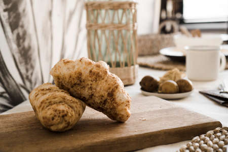 A croissant on the table. Breakfast in the kitchen - Light Scandinavian style kitchenの写真素材