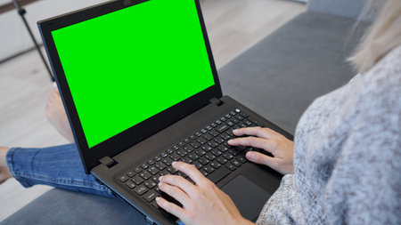 Woman using laptop with green screen. Woman typing on a laptop keyboard. Business, communication,...