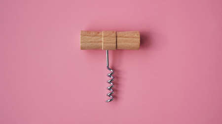 Wooden hand corkscrew on pink background with space for textの写真素材