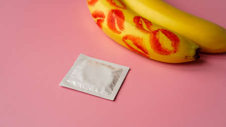 Condoms and two bananas with traces of red lipstick, concept of contraceptives and the prevention of venereal diseases.の写真素材