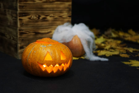 Halloween Pumpkin with fire in front of spooky dark background.