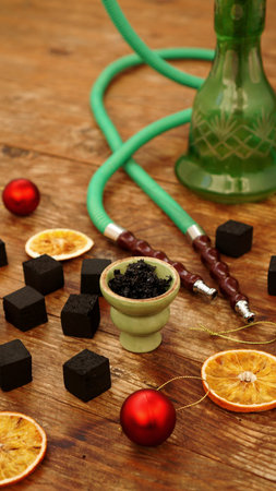 Hookah background for new year and christmas. Hookah, charcoal, dry orange slices and Christmas red...