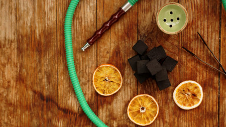 Coals for hookah on wooden background with dry oranges and bowl. Place for text and top viewの写真素材
