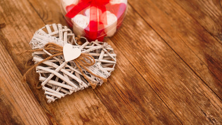 Red and white roses and Valentine day white heart on wooden background. Top view with copy spaceの写真素材
