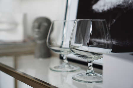 Empty glasses for whiskey on the background of a modern interior in a study or art gallery.の写真素材