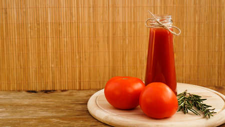 Tomato juice, fresh tomatoes on wooden background - horizontal photoの写真素材