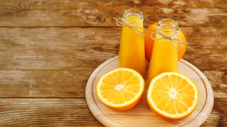 Fresh orange juice on wooden table on a wooden boardの写真素材