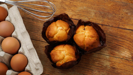 Baked cupcakes and muffins on a rustic wooden background