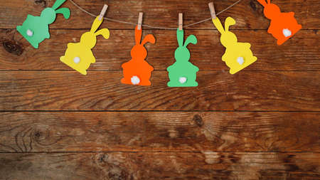 Easter background. Garland of paper rabbits on a wooden background.の写真素材
