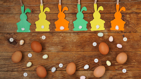 Happy Easter background. Garland of paper rabbits on a wooden background.