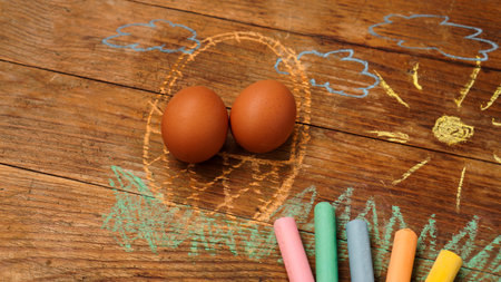Easter eggs in a basket. Drawing with colored chalk on a wooden background