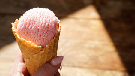 Close up image of woman hand holding two raspberry ice cream