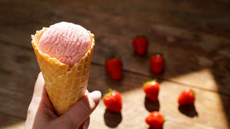 Close up image of woman hand holding raspberry ice creamの写真素材