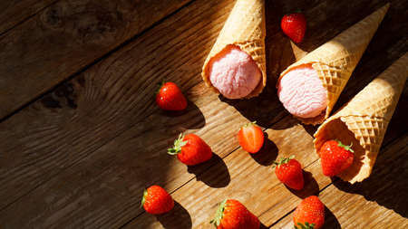 Strawberry ice cream in a waffle cone. Red berries and ice cream ballsの写真素材