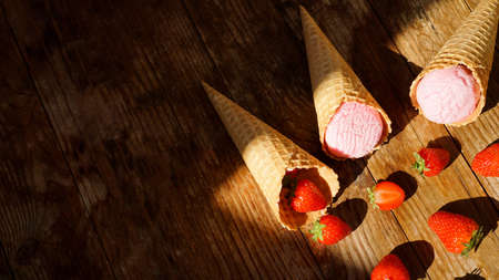 Strawberry ice cream in a waffle cone. Red berries and ice cream ballsの写真素材