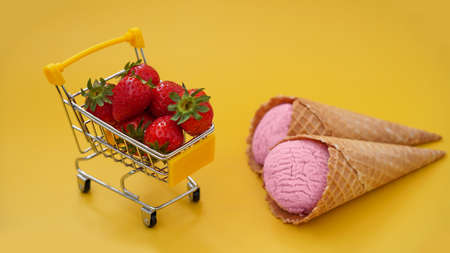 Fresh strawberries in a shopping cart and strawberry ice creamの写真素材