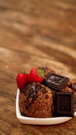 Chocolate ice cream in a bowl. Dessert decorated with chocolate and strawberries