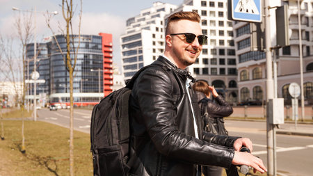 A smiling guy in sunglasses stands at the crossroads