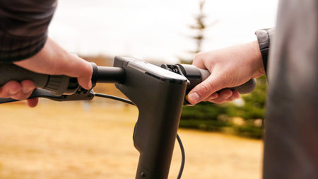 Close-up of male hand pressing speed button on electric scooter