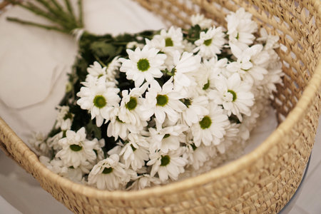 A large bouquet of daisies in a straw basketの写真素材