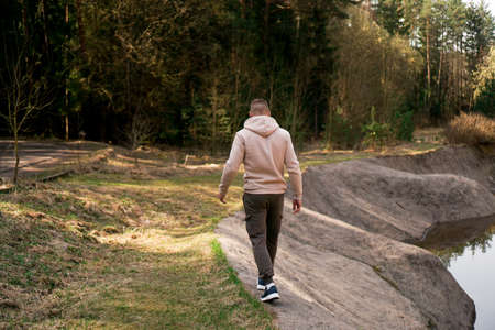 A man walks through the woods next to a rowing canal or mountain riverの写真素材