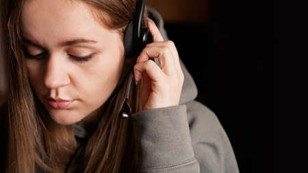 Portrait of a young girl in a hoodie and with a headset. Call center workerの写真素材