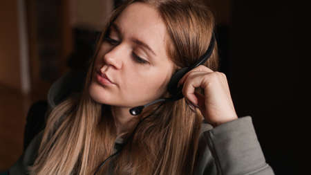 Portrait of a young girl in a hoodie and with a headset. Call center workerの写真素材