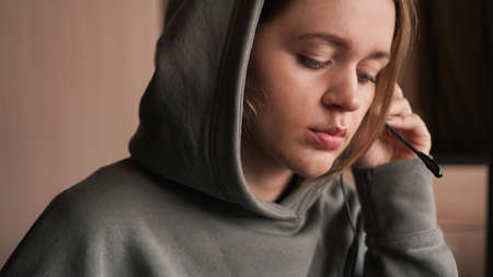 Portrait of a young girl in a hoodie and with a headset. Call center workerの写真素材