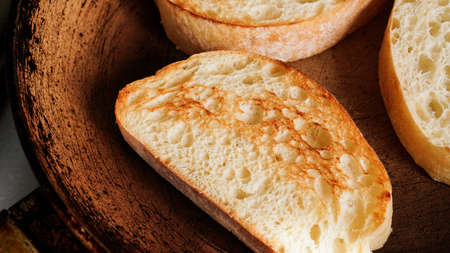 Sliced ciabatta is fried in a pan. Slice for bruschetta or breakfast.の写真素材