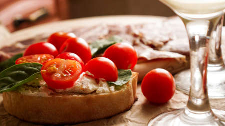 Bruschetta with cherry tomatoes. Wine glass, Italian appetizer.の写真素材