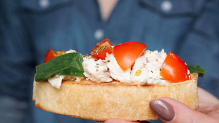 Womans hand with cherry tomato bruschetta. Italian wine appetizerの写真素材